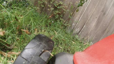 pov mowing the grass with electric lawnmower with wheel spinning