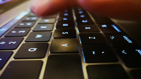 close up shot of fingers typing on laptop keyboard and scrolling and clicking on trackpad