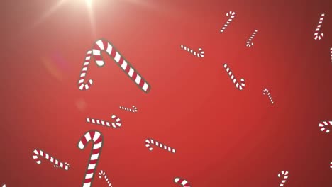 Multiple-candy-cane-icons-falling-against-spot-of-light-on-red-background