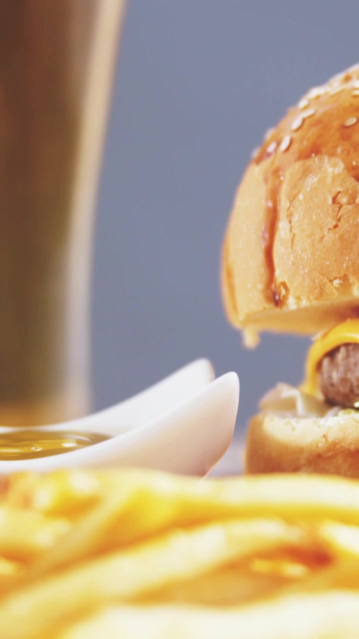 Video verticale: Badge sui post che salgono raggruppandosi sopra un hamburger, poi cadono e svaniscono per rivelare del cibo.