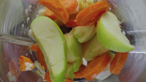 blender full fruits vegetables blending in super slow motion close up top view.