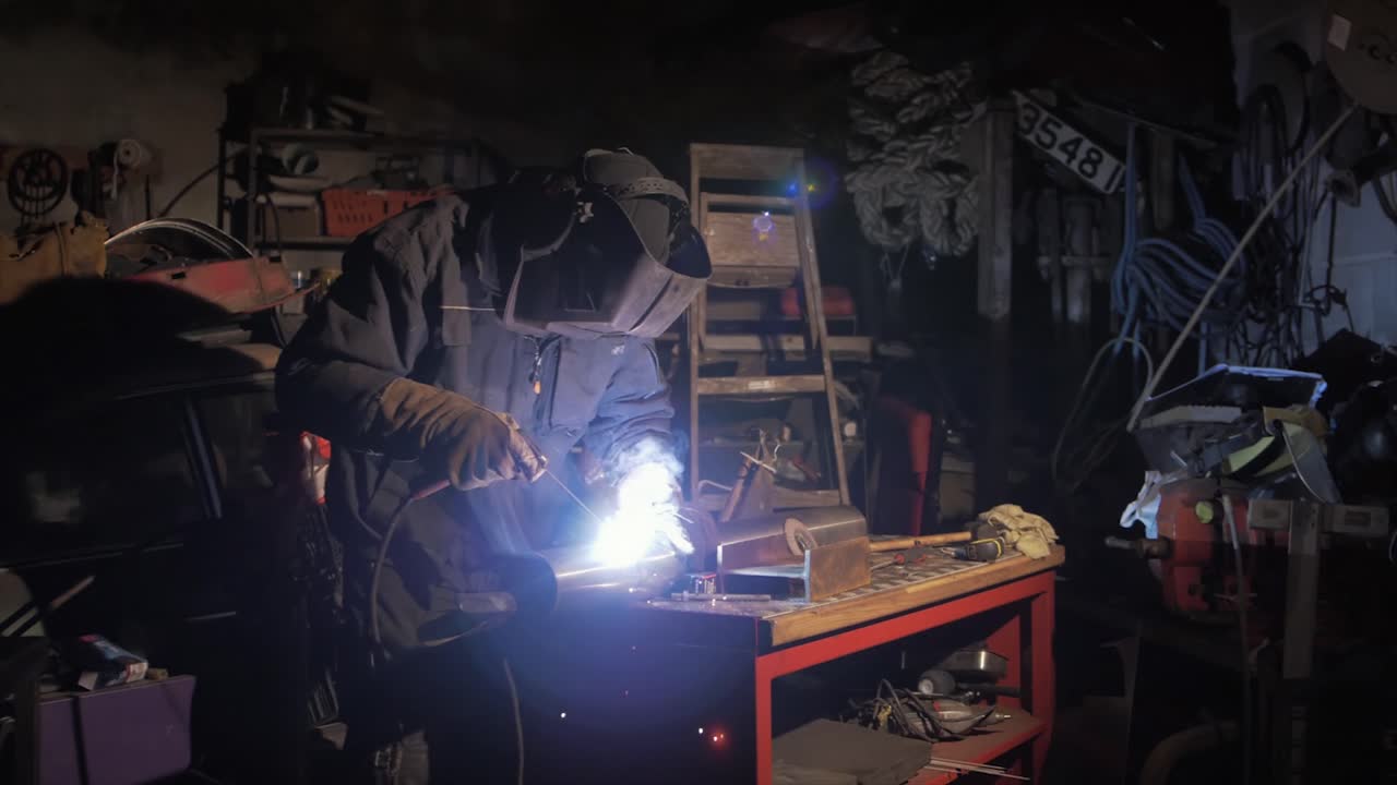 Man fabricating stainless steel pipe shielded metal arc welding in workshop