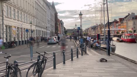 bicycles, cyclists, bikers, people pass by nyhavn, copenhagen. time lapse video. copenhagen, denmark. 2020, july.