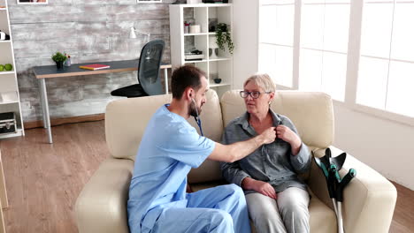 male nurse listening old woman heart beat with a stethoscope