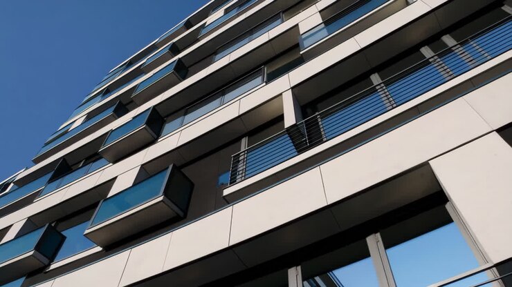 Edificio architettonico moderno con balconi contro un cielo azzurro limpido.