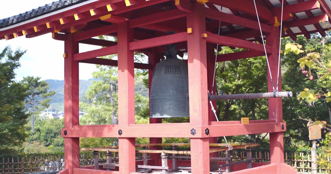 En gammel traditionel klokke står uden for et gammelt tempel i Kyoto, Japan, på en solskinsdag.