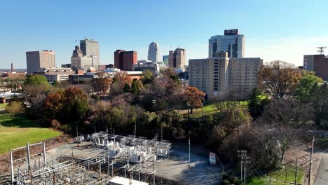 aerial-pullout-from-the-winston-salem-nc,-north-carolina-skyline-with-electrical-substation-in-the-foreground