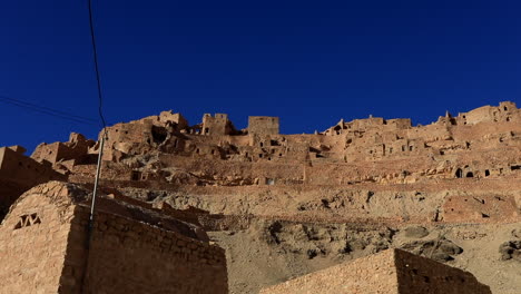 ancient ksar structures under a vibrant blue sky in tunisia's rugged landscape