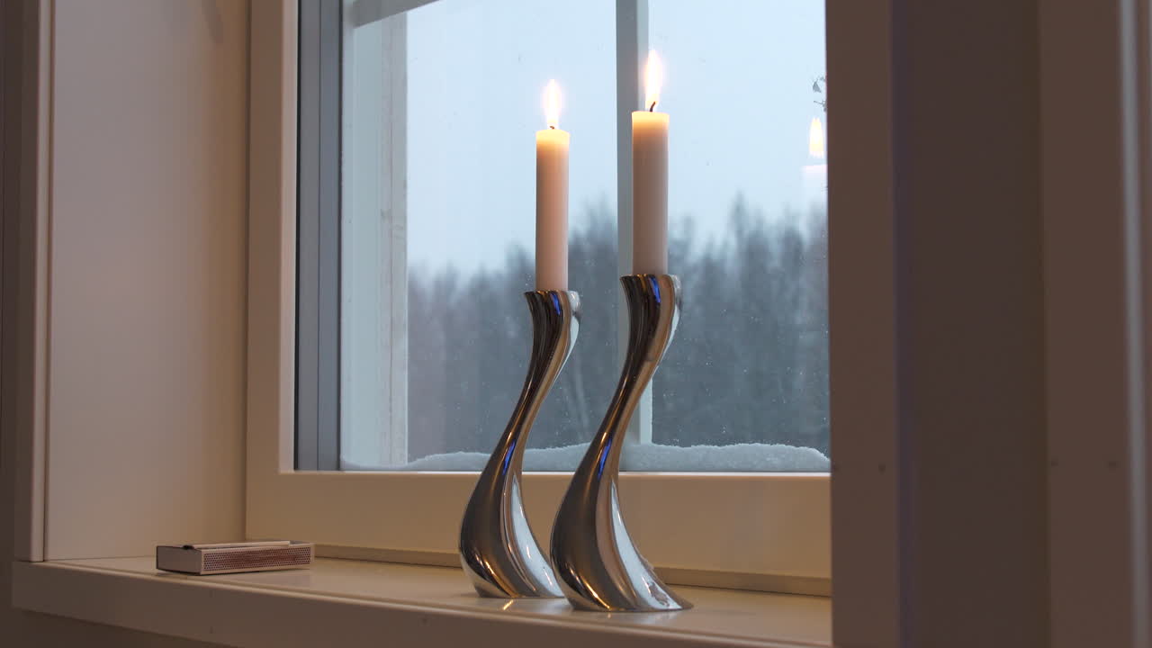 Vista statica di candelabri di design in argento sul davanzale della finestra in inverno.