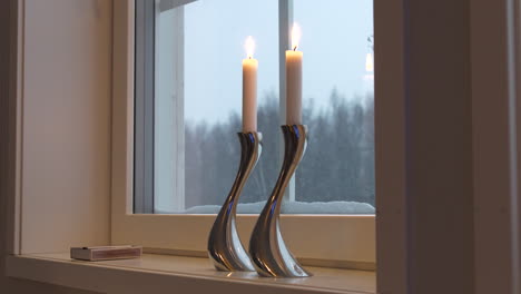 vista estática de candelabros de diseño plateado en el alféizar de la ventana en invierno