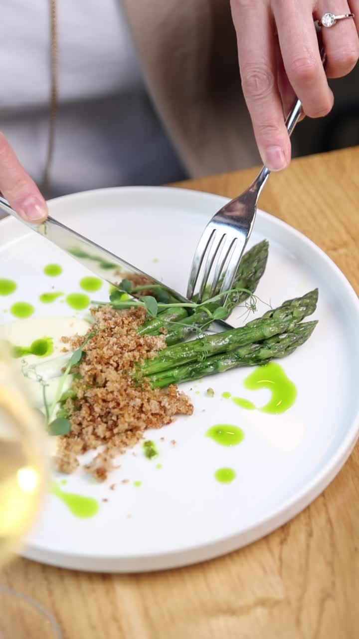 Close-up de Mãos Cortando um Prato Gourmet de Aspargos