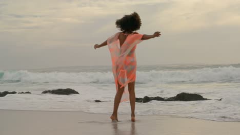 hermosa mujer de raza mixta girando en la playa