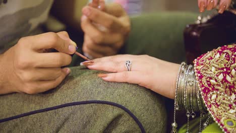 beautiful and gorgeous nail art is being applied on the bride's nails by a beautician