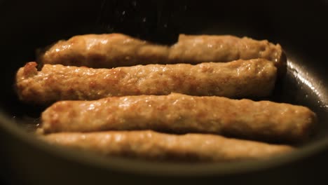 frying sausage in a pan