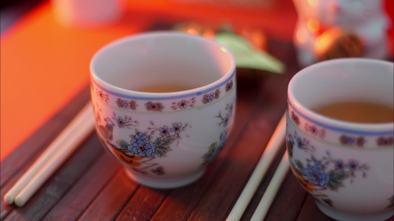Tazze da tè e bacchette tradizionali asiatiche su vassoio di legno