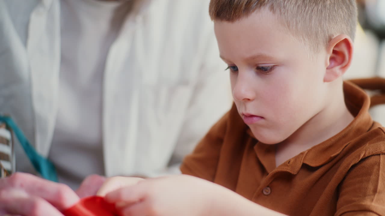 papá y el niño envuelven regalos de navidad juntos
