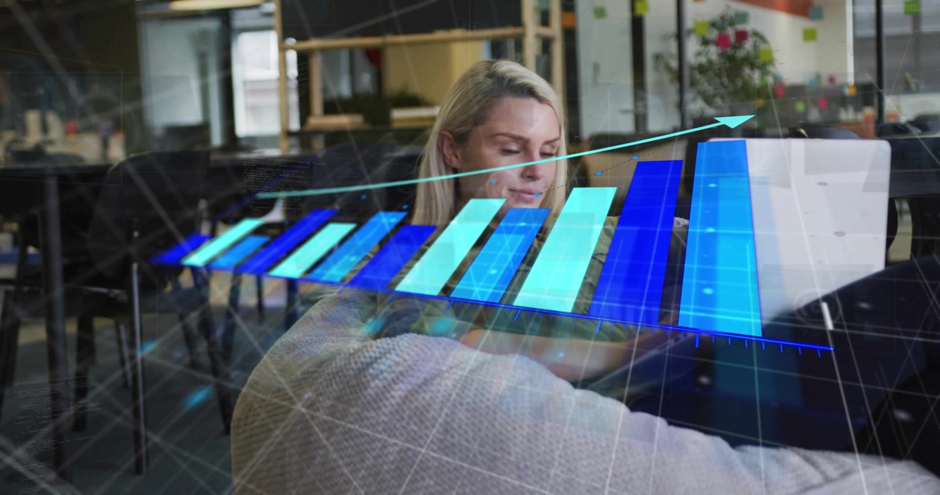 Woman using laptop in office lounge, graphics appearing and forming 3D market bars tracking rise