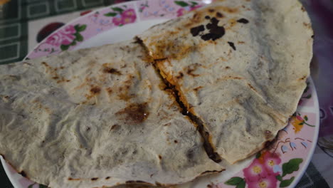 deliciosa comida local tradicional mexicana tlayuda en oaxaca, tortilla tostada con queso fresco, carne, aguacate, frijoles refritos dentro