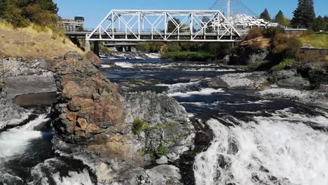 Hermosa-Vista-De-La-Cascada-De-Agua-Espumosa-En-Las-Cataratas-De-Spokane-En-Spokane,-Washington-Con-El-Puente-Del-Canal-Medio-De-La-Calle-Howard-En-El-Fondo---Toma-Completa