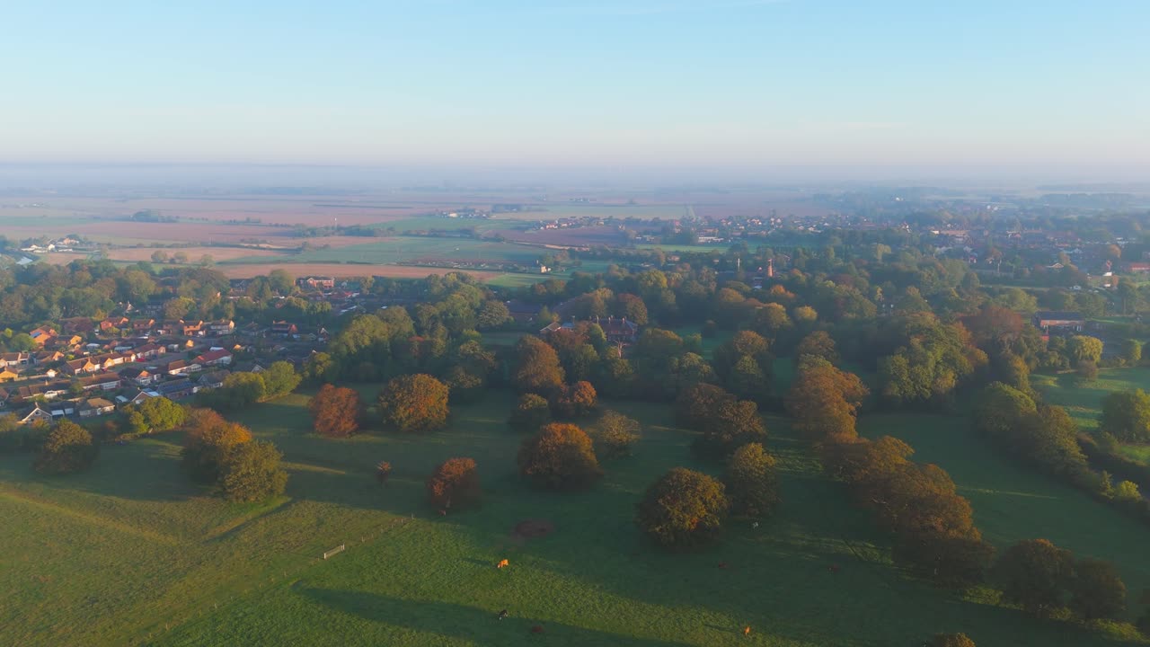 Misty autumn morning with farmlands and countryside views, wide vistas across open fields with crops set for overwintering. cold days in a rural village setting
