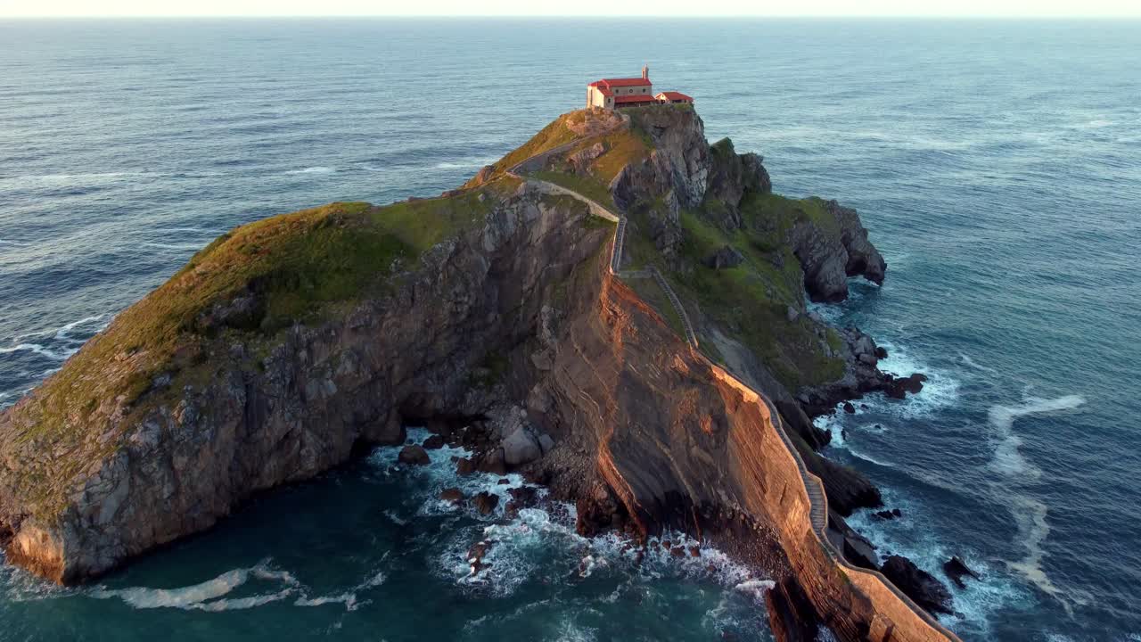Islet of Gaztelugatxeko surrounded by incredible waves of the Atlantic ocean that crash on its rocky shore