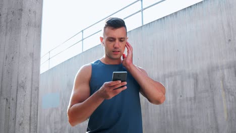 Joven-Atleta-Con-Auriculares-Y-Teléfono-Inteligente.-Concepto-De-Fitness,-Deporte-Y-Tecnología-Joven-Atleta-Con-Auriculares-Y-Teléfono-Inteligente-Escuchando-Música-Al-Aire-Libre