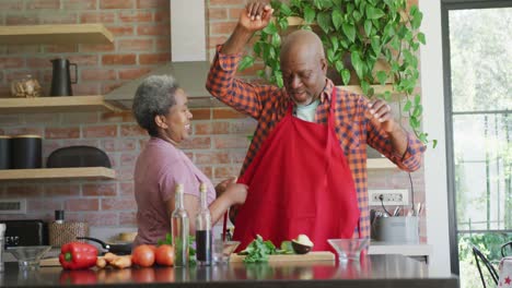 Glückliches-Afroamerikanisches-Seniorenpaar,-Das-Gemeinsam-In-Der-Küche-Kocht