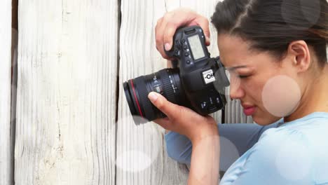 white spots against close up of caucasian female photographer clicking pictures with digital camera