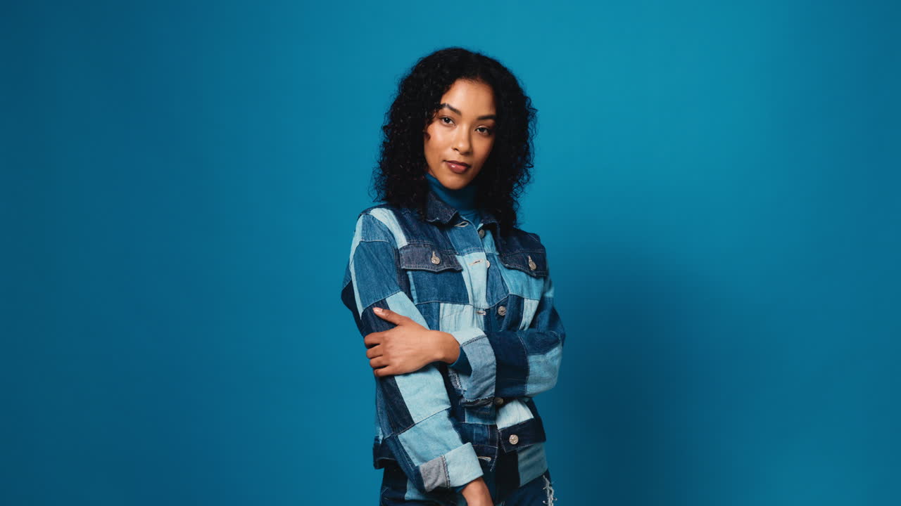 Portrait of a stylish woman in denim jacket against blue background