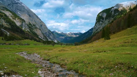 cinemagraph seamless video loop of the scenic and idyllic ahornboden mountain canyon with the river rissach with fresh blue water in the bavarian austrian alps, flowing down green lush fields