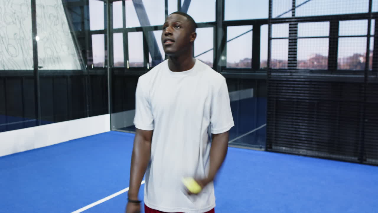 Man practicing padel tennis skills on court, focusing on ball control, copy space