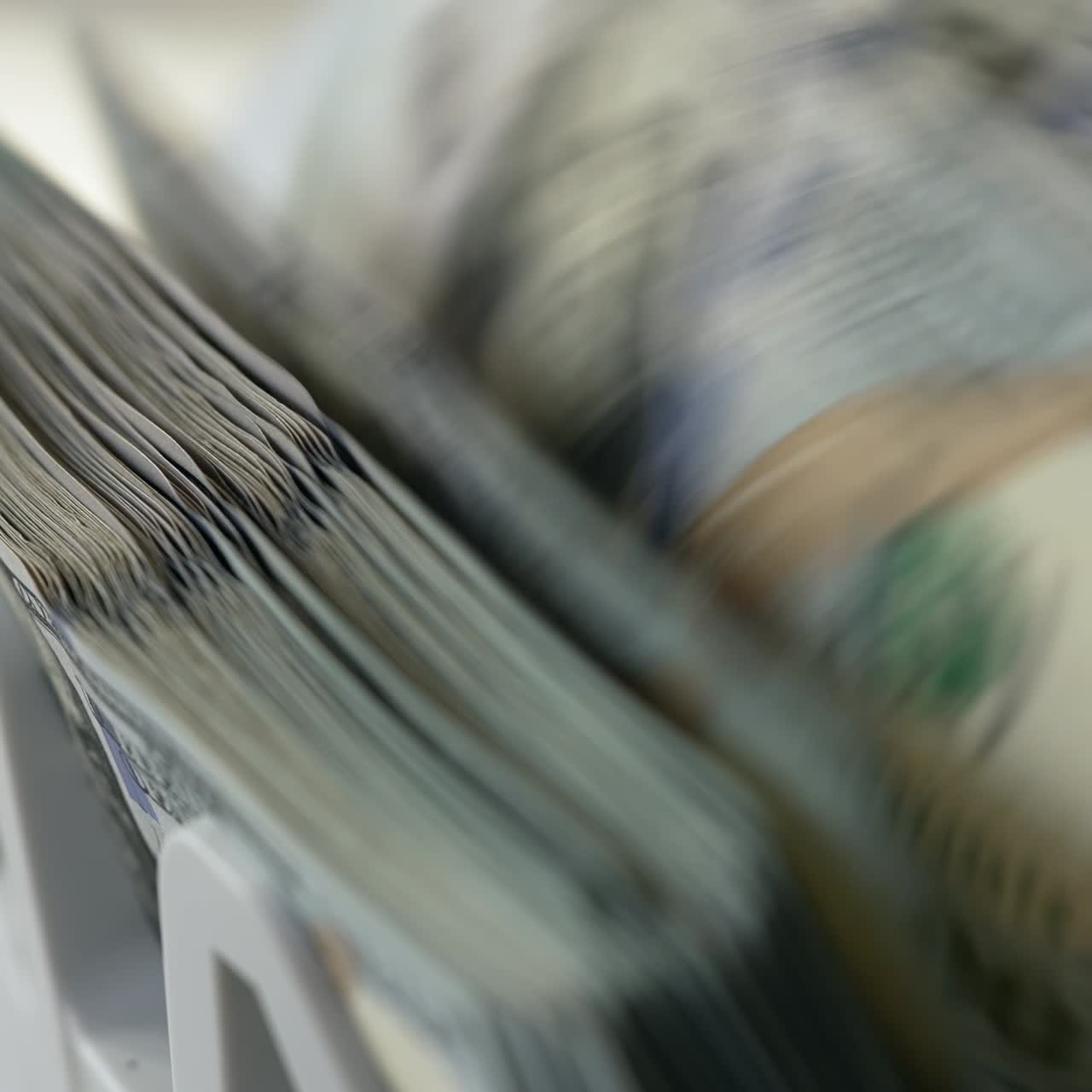 Banconote da cento dollari statunitensi che girano velocemente nella fessura del bancomat. Attrezzature per il calcolo della valuta nelle banche. Primo piano