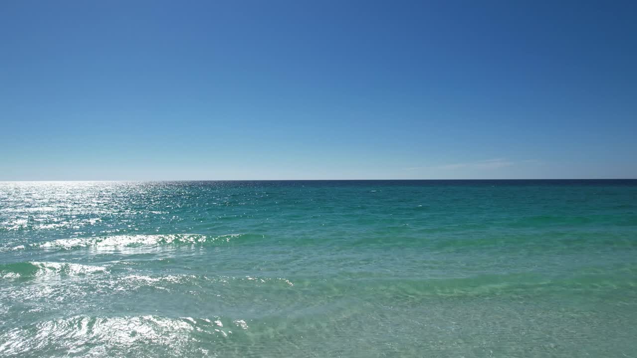 데스틴 비치 걸프 코스트 팬핸들 플로리다 백사장에 있는 파란 우산 맑고 에메랄드빛 바다가 드론 조감도로 날아가는 밝고 화창한 날