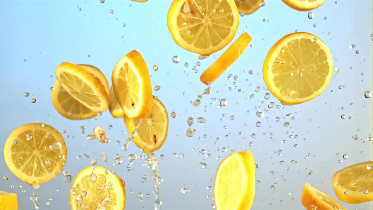 Fresh Lemon Slices and Water Droplets Falling in Slow Motion