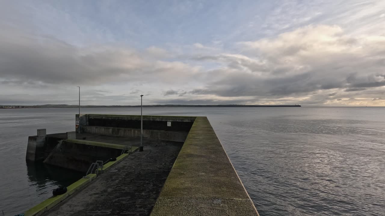 POV walking along concrete breakwater at Tramore Ireland ocean pier