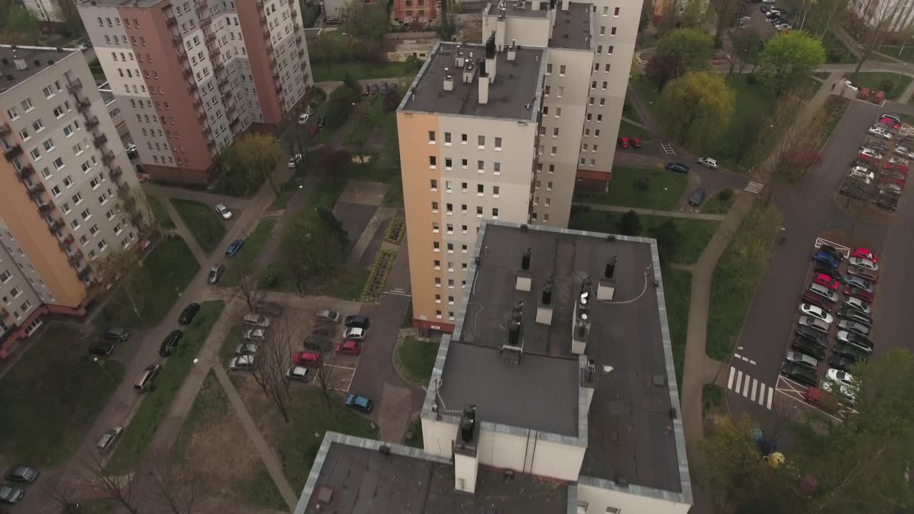 Renovated blocks from the communist era in Central Europe, surrounded by lawns and trees during spring, captured from a bird's eye view in 4K