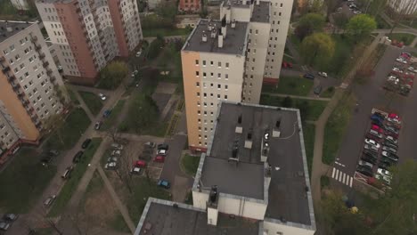 Renovated-blocks-from-the-communist-era-in-Central-Europe,-surrounded-by-lawns-and-trees-during-spring,-captured-from-a-bird's-eye-view-in-4K