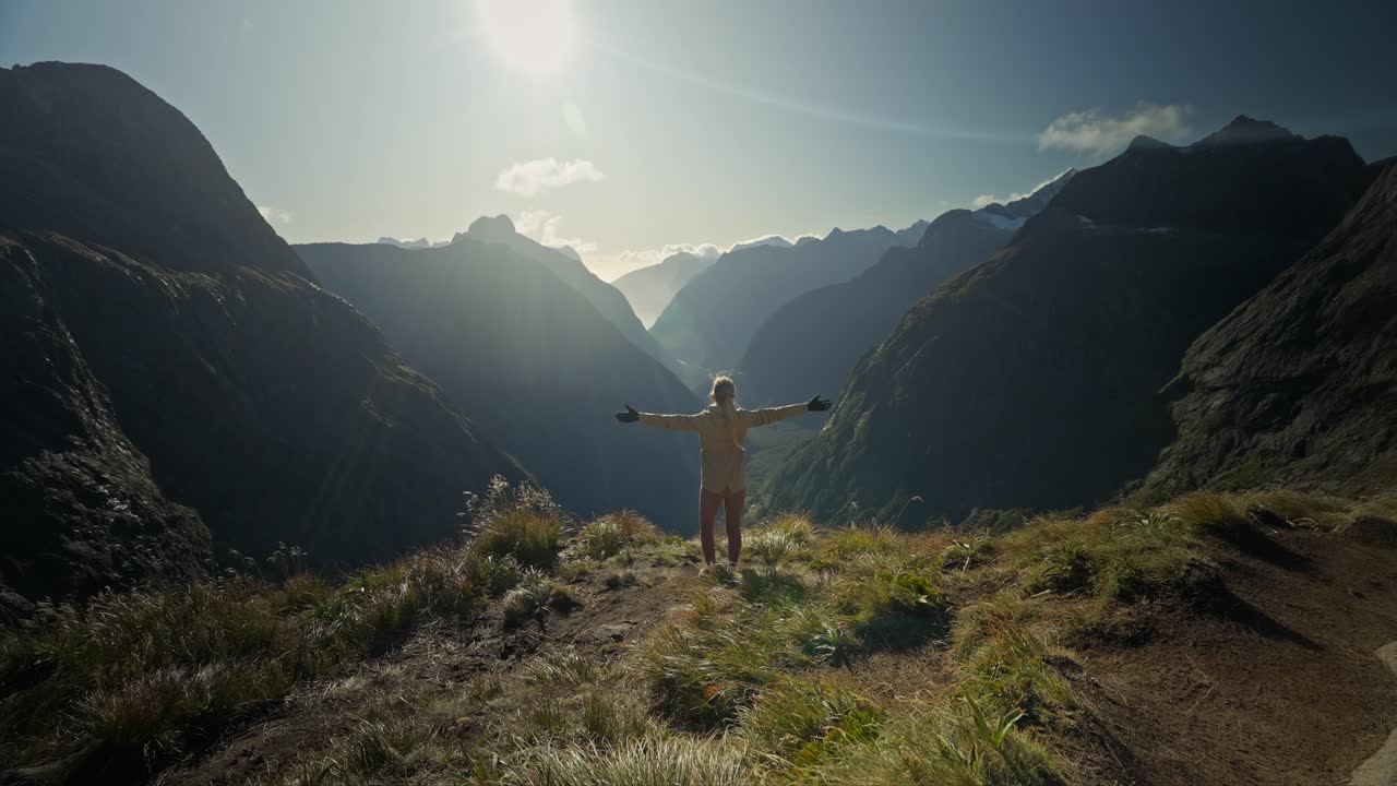 momento de alegría de la mujer llegando a un punto de vista épico en el paisaje de nueva zelanda