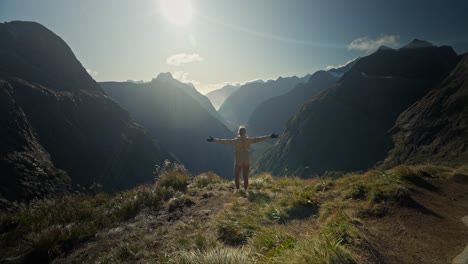 joyful moment of woman reaching epic viewpoint in new zealand landscape