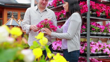 clientes de pie junto a un estante de flores