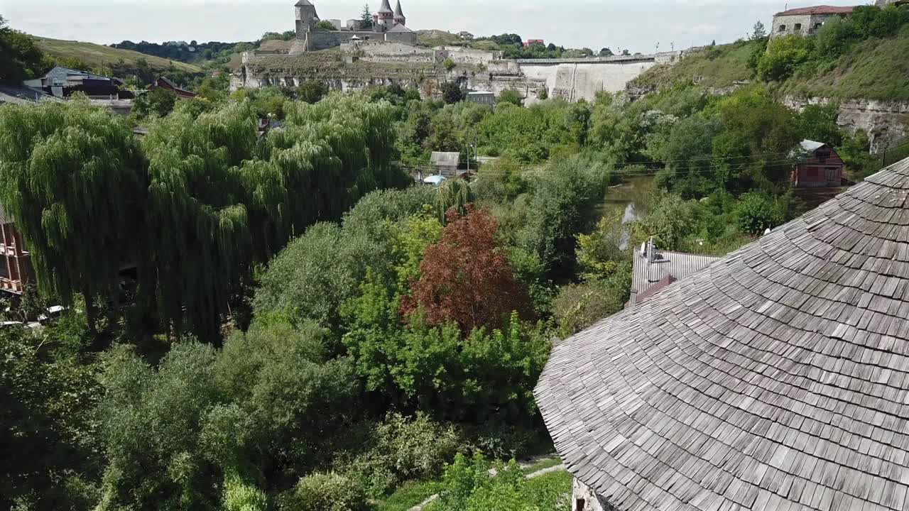 vista aérea hacia adelante hacia el viejo castillo volando sobre la torre rutenia en kamianets podilskyi, ucrania en un día soleado.