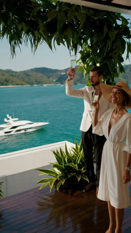 luxury couple enjoying champagne on a balcony with ocean view