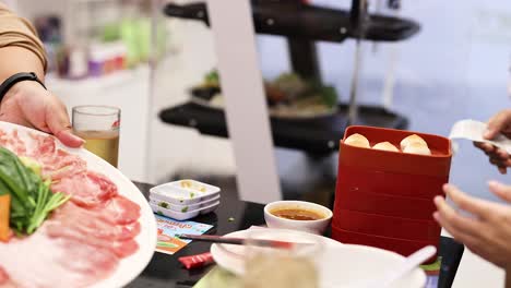friends enjoying hotpot with fresh ingredients