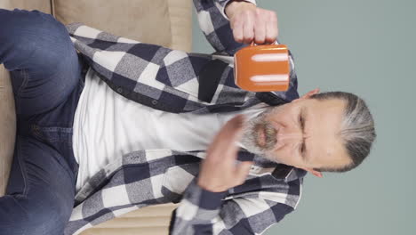 Vertical-video-of-The-old-man's-mouth-is-burning-from-the-hot-drink.