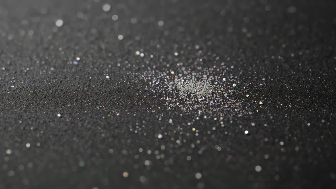 Shifting camera revealing small cluster of metallic flakes on studio table, emphasizing shimmer