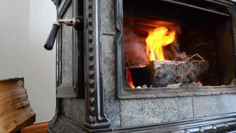 a slider shot of logs on fire in a woodburning stover fireplace on a cold winter day