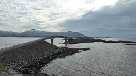 atlantic road aerial - famous norwegian road seen during quiet and partly cloudy springtime afternoon - slowly moving backwards close to storseisundet bridge