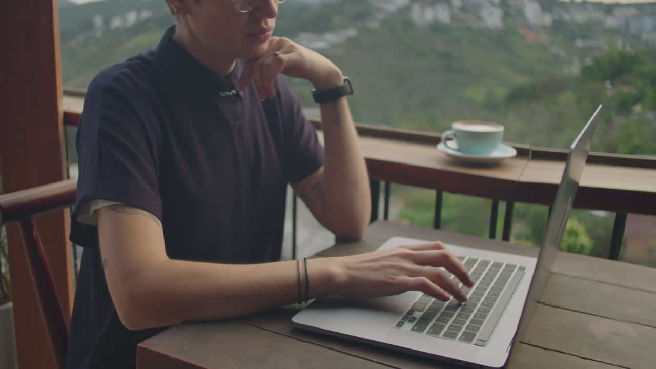 Businesswoman Working on Laptop in Cafe with Mountain View