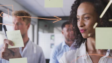 Professional-businesswoman-sticking-memo-notes-on-glass-board-in-modern-office-in-slow-motion