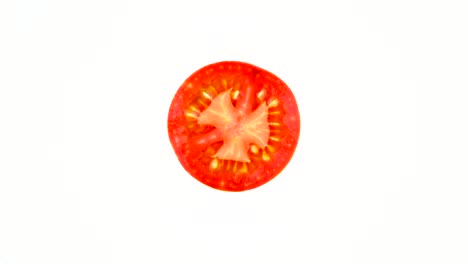 top view from above of red globe striped tomato cross section. rotating on the turntable isolated on the white background. close-up. macro.